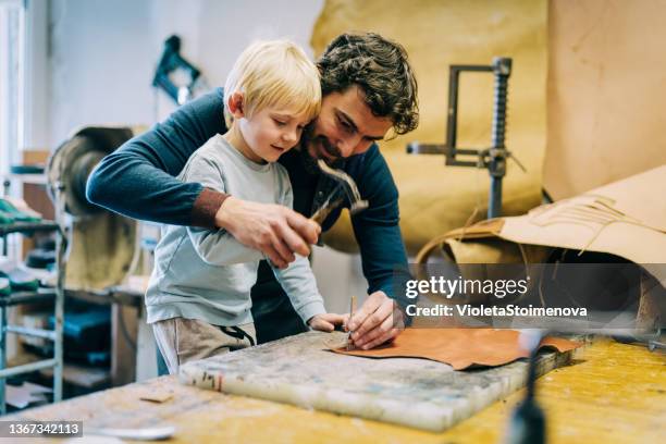 artisan et son mignon petit garçon fabriquant une ceinture en cuir. - maroquinerie photos et images de collection