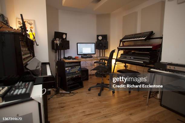 Keyboards on stands, piano amplifiers and computer recording and editing equipment in recording studio, London, 2016.
