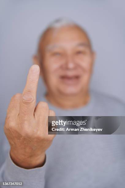 senior man at the wall making middle finger gesture - middle finger funny - fotografias e filmes do acervo