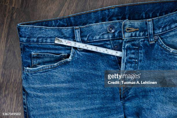 measuring tape coming out from unbuttoned fly of jeans. - measure length stock pictures, royalty-free photos & images