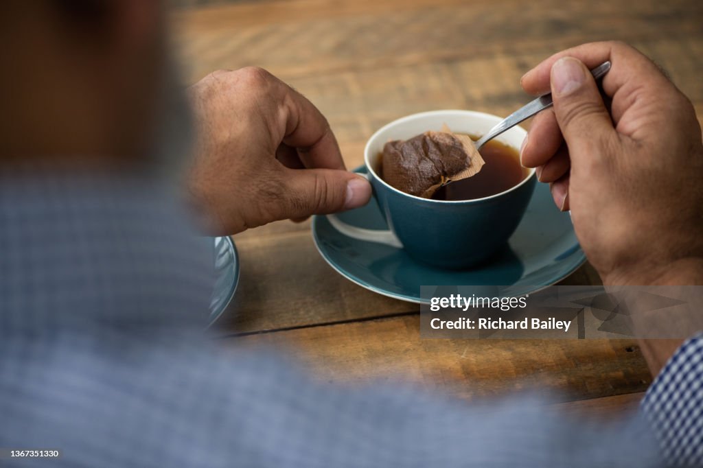 Unrecognisable making a cup of tea using a single tea bag in the cup