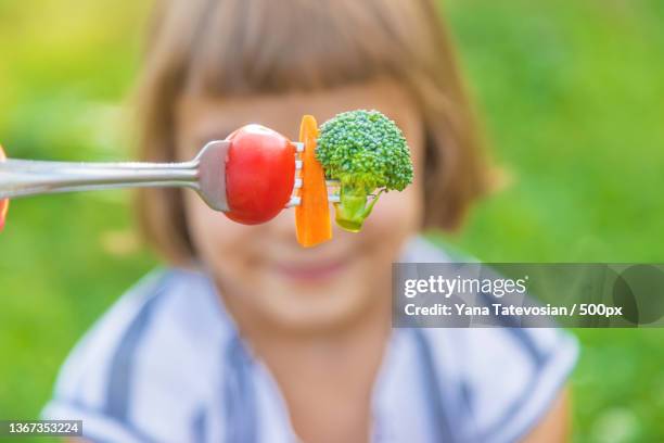 child eats vegetables broccoli and carrots selective focus - hate broccoli stock pictures, royalty-free photos & images