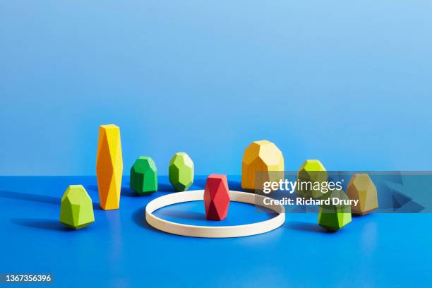 conceptual image of geometric pebbles - caught in the act stockfoto's en -beelden