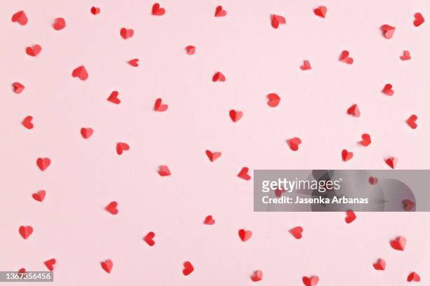 red heart confetti on pink background - roze achtergrond stockfoto's en -beelden