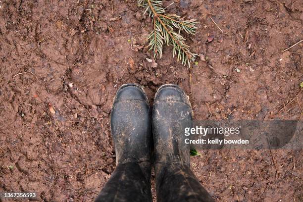muddy wellies wellinton boots in mud hiking walking - dirty feet stock-fotos und bilder
