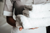 Close up of a young maid holding folded towels