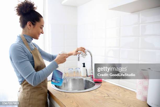 young woman polishing a faucet - sink stock pictures, royalty-free photos & images