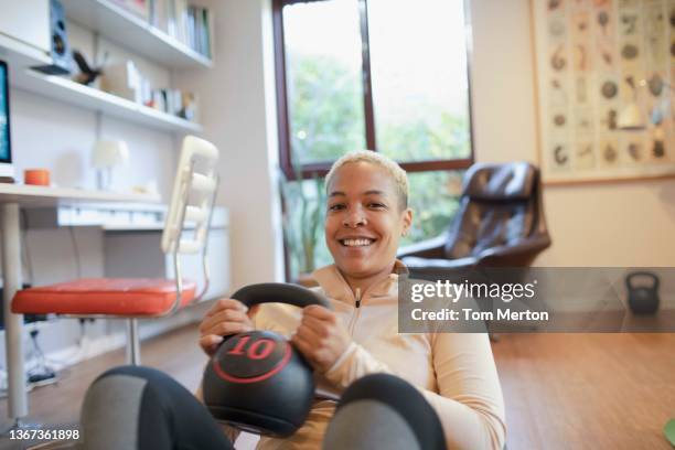 uk, london, richmond, portrait of smiling woman exercising at home - kettlebell stock pictures, royalty-free photos & images