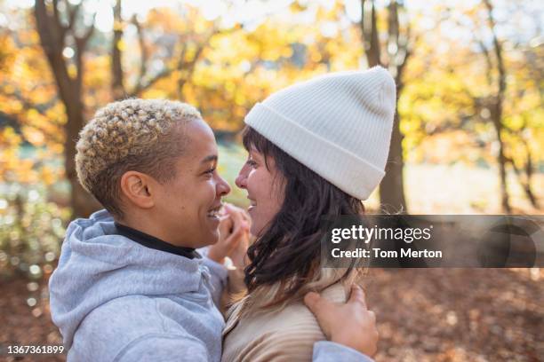 uk, london, richmond, smiling lesbian couple dancing in autumn park - couple short hair stock-fotos und bilder