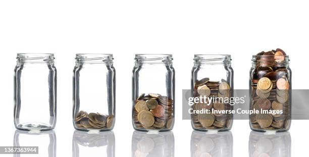 stack of coins bottle - jar stockfoto's en -beelden