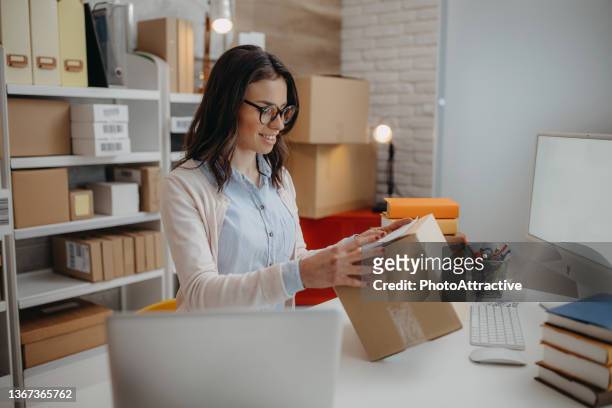 woman packs the books for delivery - office small business stock pictures, royalty-free photos & images