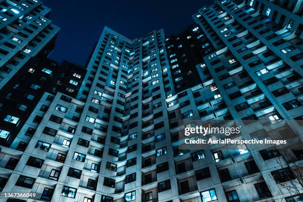 low angle view of residential building and neighborhood at night - building story stock-fotos und bilder