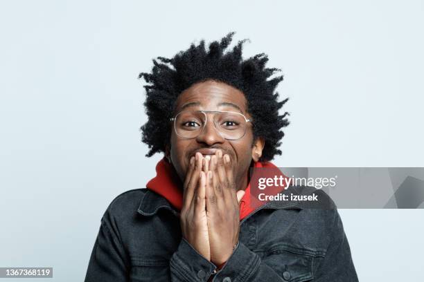 hombre emocionado con sudadera roja con capucha - mano tapando la boca fotografías e imágenes de stock