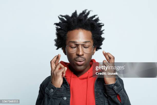 headshot of man crossing fingers - fingers crossed stock pictures, royalty-free photos & images