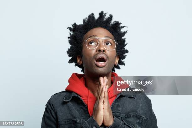 worried man in red hoodie - pleading stock pictures, royalty-free photos & images
