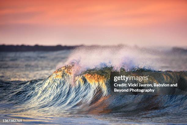 amazing light illuminating wave crashing at cape may, new jersey - jersey shore new jersey photos et images de collection