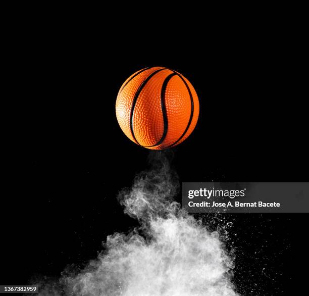 impact and rebound of a ball of basketball on a surface of land and powder on a black background - ballon rebond stock pictures, royalty-free photos & images