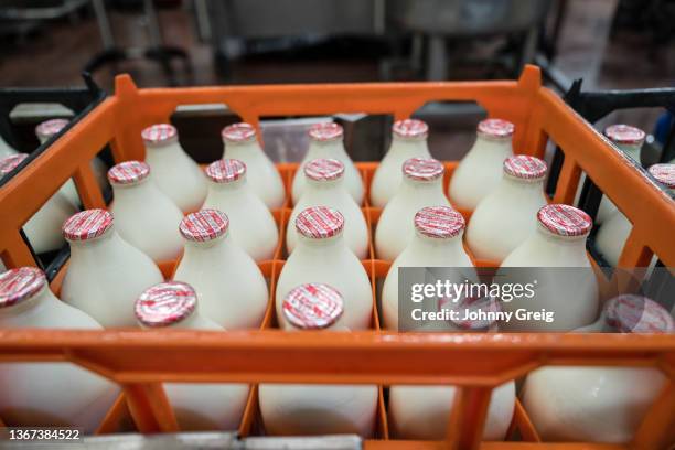 orange crate filled with milk bottles ready for delivery - milk bottle stock-fotos und bilder