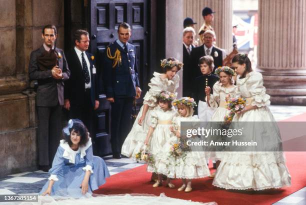 Wedding dress designer Elizabeth Emanuel , straightens the train of Diana, Princess of Wales' dress as bridesmaids India Hicks , Clementine Hambro ,...