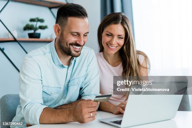 pareja encantadora que usa computadora portátil para compras en línea. - credit union fotografías e imágenes de stock