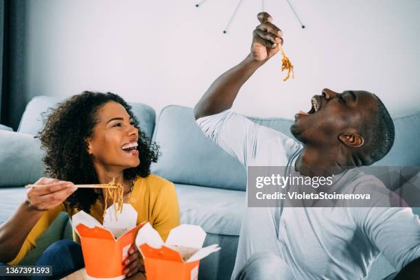 feliz pareja comiendo comida china en casa. - food delivery fotografías e imágenes de stock