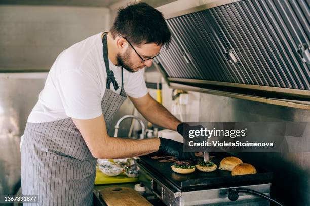 happy chef preparing burgers in his food truck. - bbq sandwich stockfoto's en -beelden