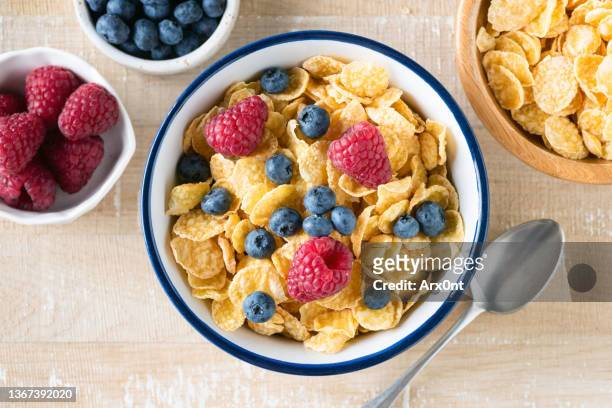 bowl of cornflakes with fresh berries - bowl of cornflakes stock-fotos und bilder