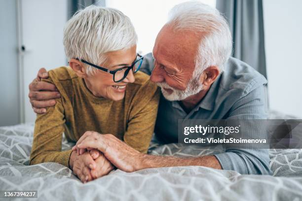 paar entspannen im schlafzimmer. - man and woman cuddling in bed stock-fotos und bilder