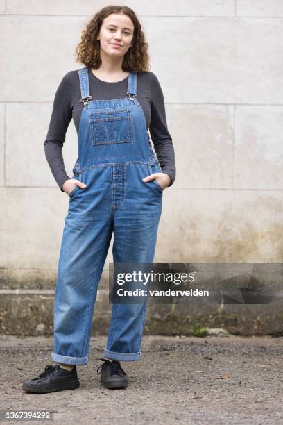 young lady wearing bib overalls - tuinbroek stockfoto's en -beelden
