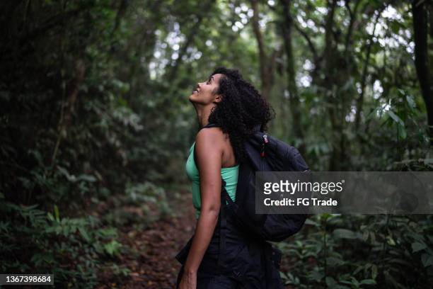 mittelgroße frau, die die natur betrachtet - african american hiking stock-fotos und bilder