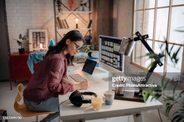 fotógrafo de edición de fotos en su computadora. - deitando fotografías e imágenes de stock