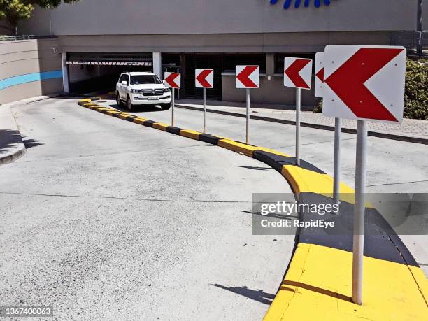 red-and-white chevrons point the way into underground parking garage - entry car imagens e fotografias de stock