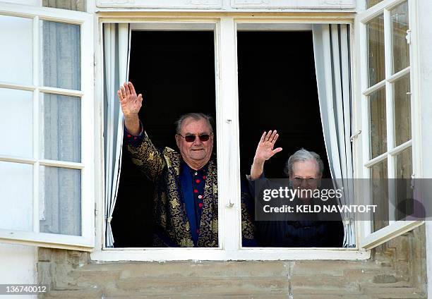 Queen Margrethe II of Denmark and Prince Consort Henrik wave to wellwishers from a window of the Fredensborg Palace residence near Copenhagen on...