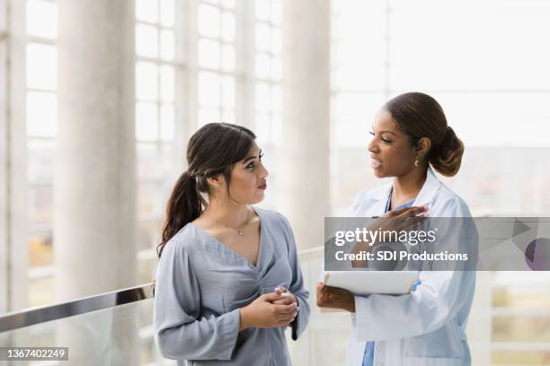 doctor and young adult woman discuss test results - 20s talking serious bildbanksfoton och bilder