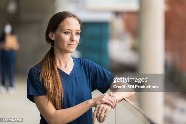 chirurgin macht pause auf krankenhausbalkon - respite care stock-fotos und bilder