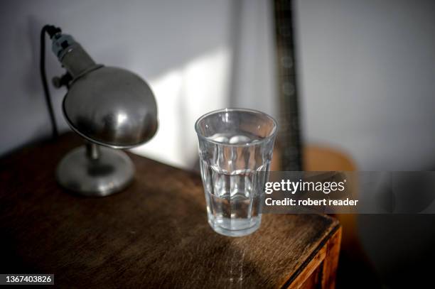 glass of water on bedside table - bedside table stock pictures, royalty-free photos & images