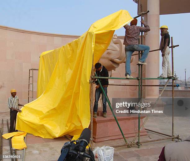 Workers covering the giant elephant statues at Ambedkar memorial Park with tarpaulin sheets on January 10, 2012 in Lucknow, India. India's Election...