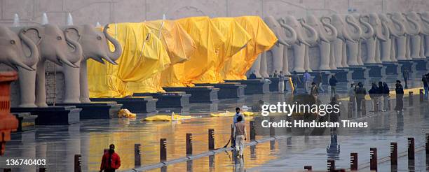 Workers covering the giant elephant statues at Ambedkar memorial Park with tarpaulin sheets on January 10, 2012 in Lucknow, India. India's Election...
