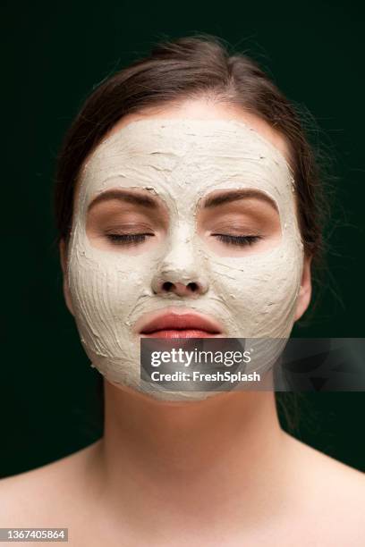 retrato de una hermosa mujer joven de talla grande con una máscara facial cosmética como parte de su rutina de cuidado de la piel - máscara facial fotografías e imágenes de stock
