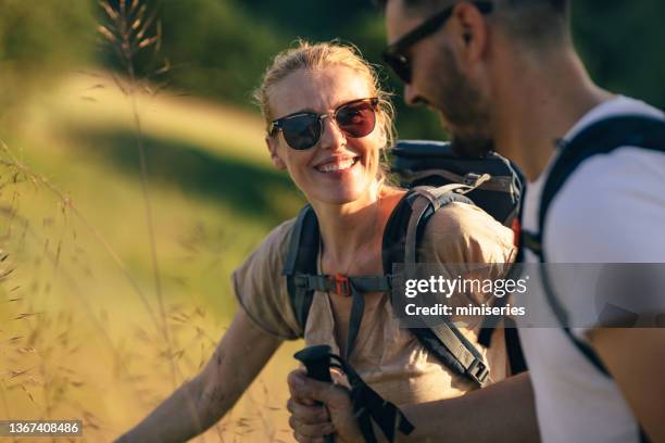 portrait of a beautiful woman smiling while hiking with husband - twee ouders stockfoto's en -beelden