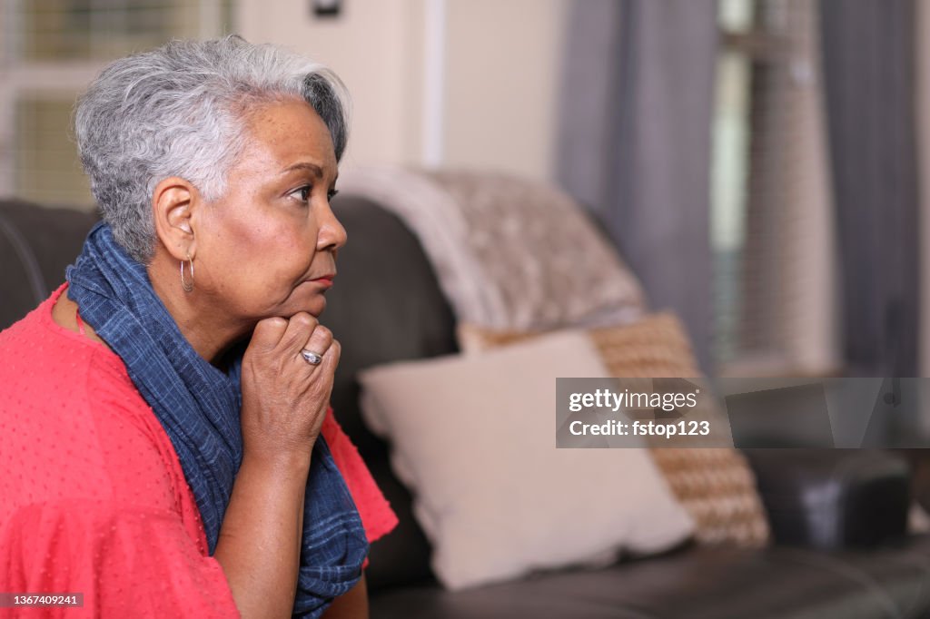 Sad, depressed senior adult woman at home.