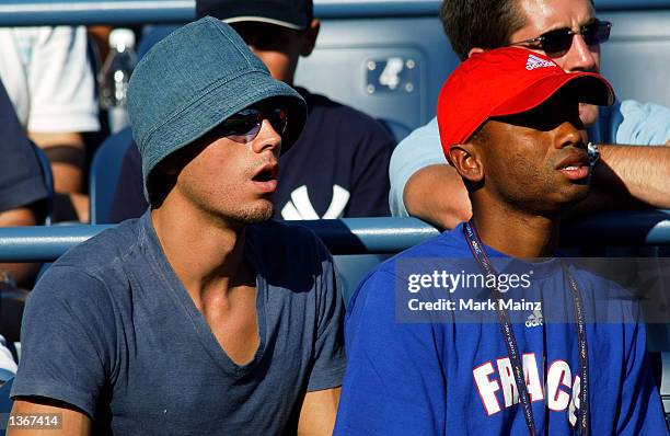 Singer/songwriter Enrique Iglesias watches his girlfriend Anna Kournikova play a doubles match at the U.S. Open September 4, 2002 in Flushing...