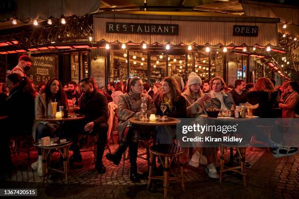 Parisians enjoy a weekend drink on a terrace of a Paris Cafe, as France records over half a million Covid-19 cases in one day fuelled by the Omicron...