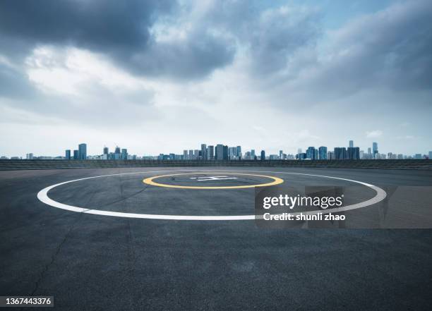 helipad against urban skyline - helikopterplatform stockfoto's en -beelden