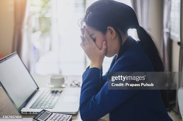 frustrated female computer programmer with head in hands sitting in creative - bored housewife stock-fotos und bilder