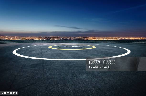 helipad against urban skyline at night - helipad stock pictures, royalty-free photos & images