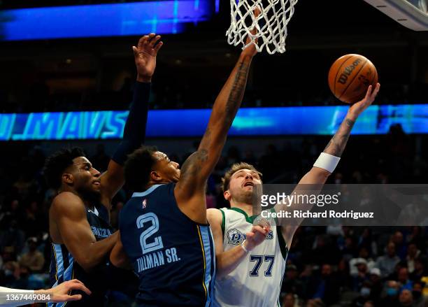 Jaren Jackson Jr. #13 and Xavier Tillman of the Memphis Grizzlies defend against a shot by Luka Doncic of the Dallas Mavericks at American Airlines...