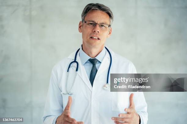 portrait of senior smiling doctor - stay at home saying stock pictures, royalty-free photos & images