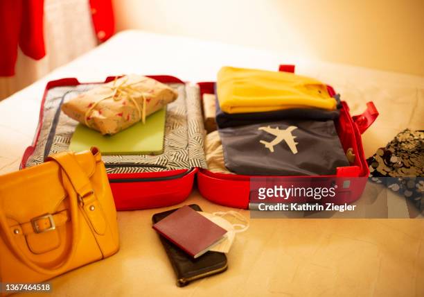 packed suitcase lying open on bed - hand luggage stock pictures, royalty-free photos & images