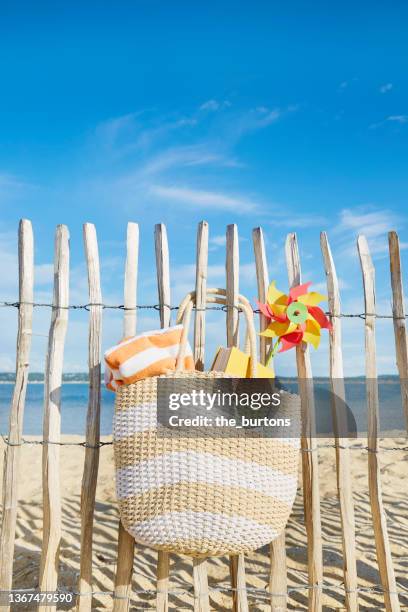 beach bag hanging at a fence at the sea against blue sky - healthy lifestyle no people stock pictures, royalty-free photos & images